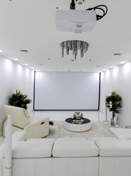 Modern basement home theatre with projector, recessed lighting, and in-ceiling speakers wired by Inline Electric