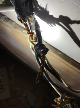 Dangerous knob and tube wiring connection with exposed copper and deteriorated insulation